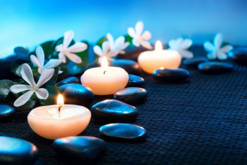 candles and black stones on black mat - 901140874