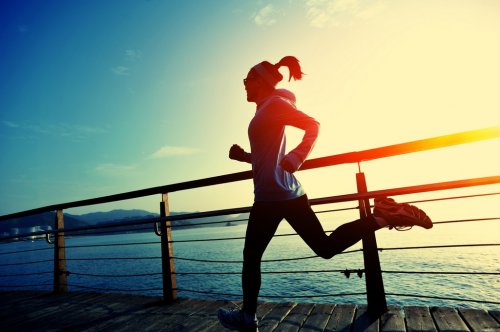 young fitness woman running on seaside boardwalk - 901145166