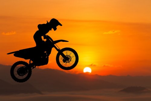 silhouette of biker jumping