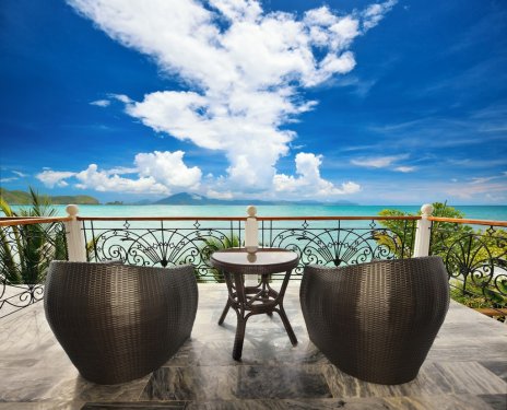 Terrace lounge with rattan armchairs and seaview.