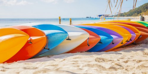 Row of colorful kayaks at sea shore on Tangalooma Island, Queensland. - 901147861