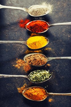 Colorful spices in metal spoons
