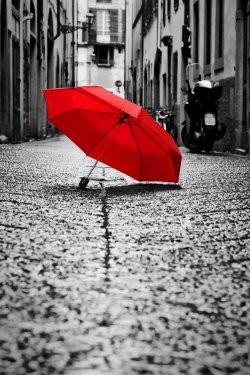 Red umbrella on cobblestone street in the old town. Wind and rain - 901152779