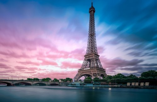 Long exposure photographyof the Eiffel Tower from Seine river with evening purple blue sky