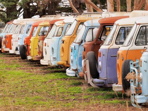 Row of defunct colorful and run down desolate vans of all the same Volkswagen Bully type, Australia 2016