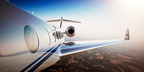 Photo of White Luxury Generic Design Private Jet Flying in Blue Sky at sunset. - 901155230