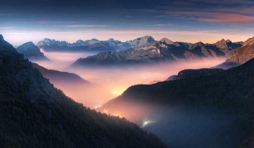 Mountains in fog at beautiful night in autumn in Dolomites, Italy.