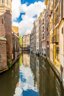 Narrow Amsterdam canal and dutch medieval architecture on a sunny morning