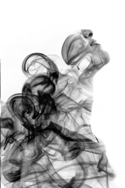 Double exposure portrait of a young exotic woman and a smoky texture dissolving into her facial features. Black and white