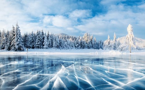 Blue ice and cracks on the surface of the ice. Frozen lake under a blue sky i... - 901156842