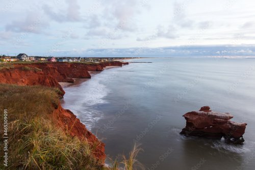 Falaises de grès rouge, des rochers empilés et de la plage des Dunes-du-Sud vues lors d'un lever de soleil d'automne nuageux, Havre-aux-Maisons, Îles-de-la-Madeleine, Québec, Canada