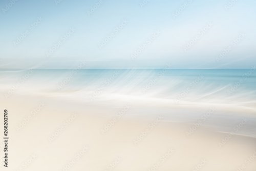 Blurred waves at the beach on a clear day in spring - 901158439
